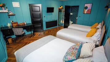 A room with two beds, a desk, a chair, a television, and a mirror.