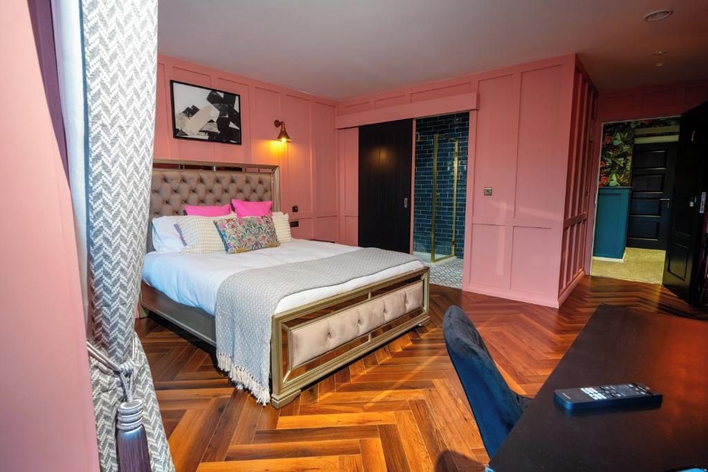 A bedroom with a large bed, a desk, and a wardrobe.