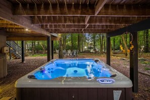 A hot tub under a wooden pergola in a wooded area with outdoor seating. - Honky Tonk Karaoke! Hot Tub - Sauna - 5 min wlk 2 lake (Lake Harmony)