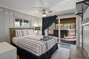 A bedroom with a bed, a ceiling fan, a window, and a view of an outdoor area. - Honky Tonk Karaoke! Hot Tub - Sauna - 5 min wlk 2 lake (Lake Harmony)