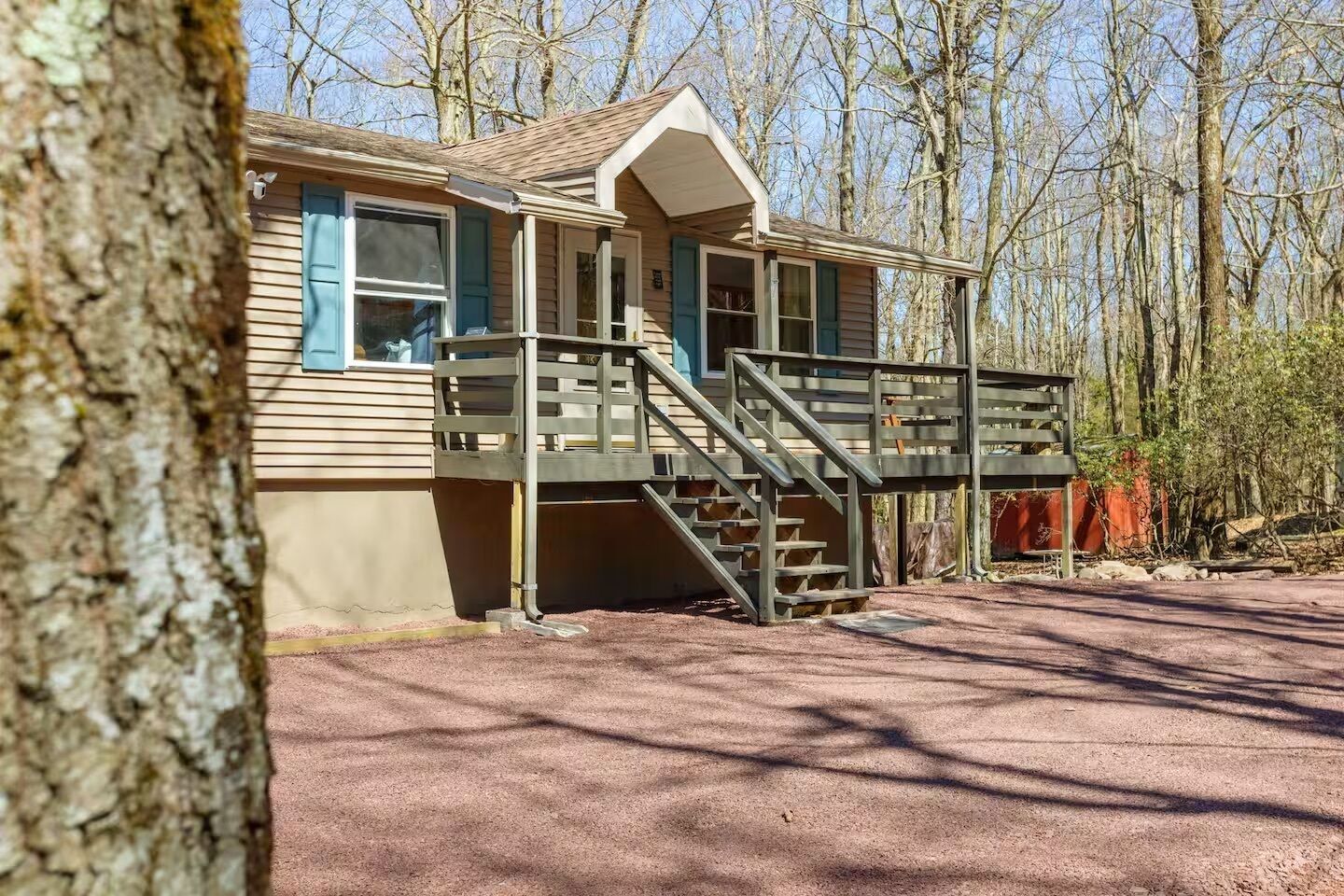 A cabin with a porch and a staircase leading to a deck.