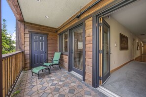A covered outdoor area with a door, two chairs, and a tiled floor. - Yocum Ridge Condo 204 at South Grand Lodge | Best Mt. Hood View (Government Camp)