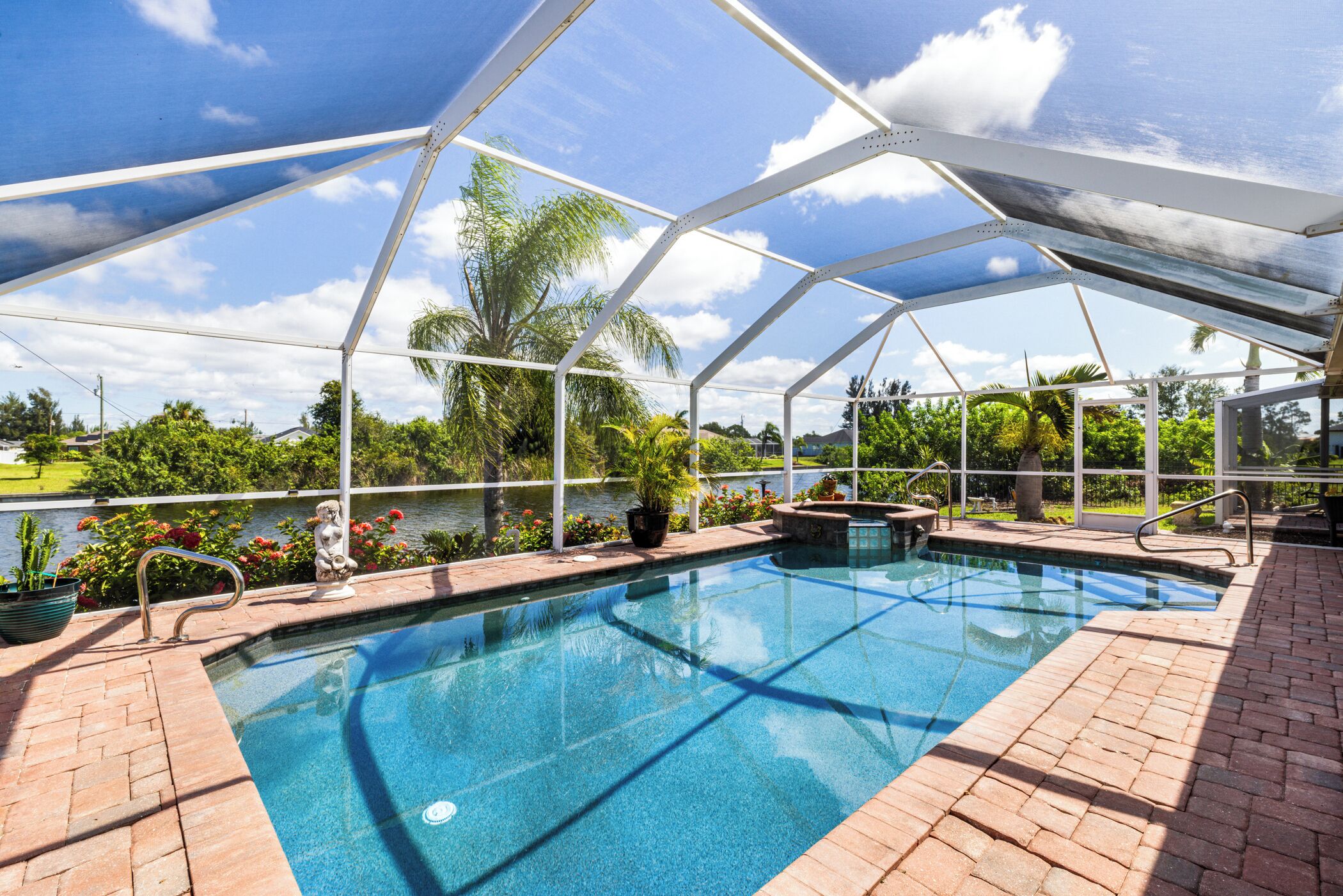A covered swimming pool with a view of a lake and surrounding greenery.