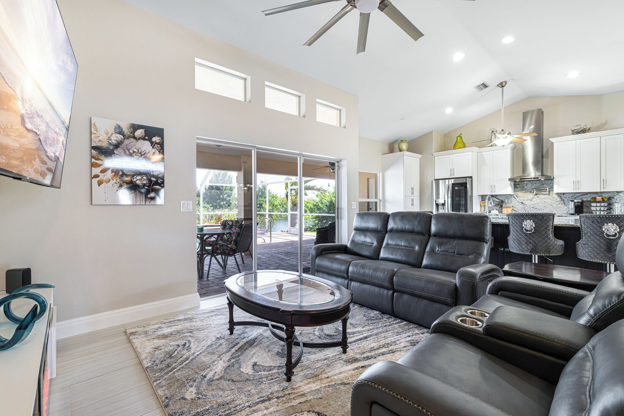 A modern living room with a leather sofa, a glass coffee table, and a dining area with a table and chairs.