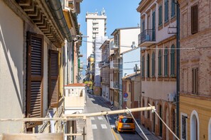 A narrow street flanked by buildings with balconies and a clear sky. - Casa La Conchiglia - Casa la Conchiglia (Porto Recanati)