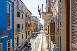 A narrow street with buildings on both sides, a scooter parked on the street, and a closed shutter on the right. - Casa La Conchiglia - Casa la Conchiglia (Porto Recanati)