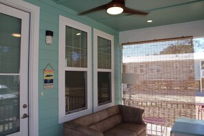 A room with teal walls, a ceiling fan, and a window with blinds.