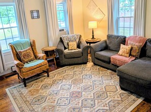 A living room with a patterned rug, two armchairs, a sofa, and a lamp. - The 1860 Farmhouse: A Peaceful New England Retreat (Barrington)