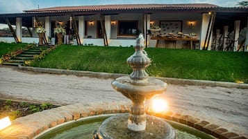 A fountain in a circular basin with a building in the background.