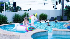A swimming pool with a unicorn float and lounge chairs. - Affordable townhouse Retreat| Pool| Prime Location (Eight Mile Plains)