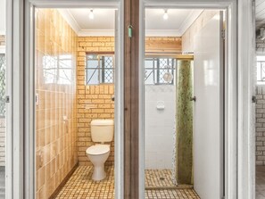 A bathroom with a toilet, a shower, and a tiled floor. - Great value Sunnybank Family Stay | Pool | Parking (Sunnybank)