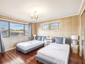 A hotel room with two beds, a desk, a chair, a lamp, and a window with a view. - Great value Sunnybank Family Stay | Pool | Parking (Sunnybank)