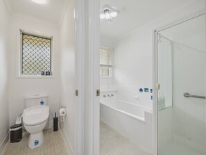 Ein Badezimmer mit Toilette, Bidet und einer Duschkabine.