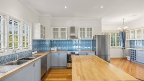 Una cocina moderna con una isla central, electrodomésticos integrados y un salpicadero de azulejos azules.