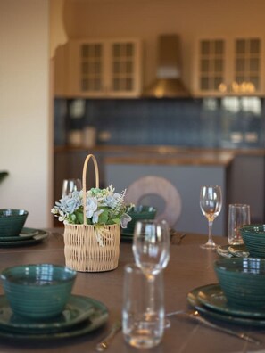 A dining table set with green plates, bowls, and a clear glass pitcher. - Character Home| Mt Coot-tha Views | Prime location (Sherwood)