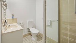 A bathroom with a toilet, sink, and shower area. - GreatValue Stay| Pool | Parking | Prime Location (Eight Mile Plains)