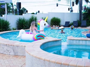 En pool med en uppblåsbar enhörning och en uppblåsbar svan.