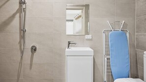 A bathroom with a shower, sink, mirror, and a towel rack. - Great Value Studio |Fully Renovated|Prime Location (Robertson)