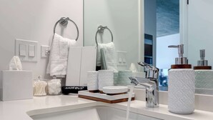 A modern bathroom with a white sink, chrome fixtures, and a large mirror. - Wabash 4BR - Pool, Free In & Out Parking 1 (Chicago)