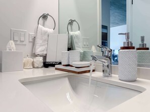 A modern bathroom with a white sink, chrome fixtures, and a large mirror. - Wabash 4BR - Pool, Free In & Out Parking 1 (Chicago)