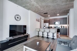 Ein modernes Wohnzimmer mit Flachbildfernseher, Couchtisch und Sofa.
