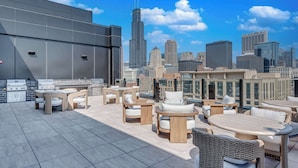 A rooftop terrace with outdoor seating and a city skyline view. - Wabash 4BR - Pool, Free In & Out Parking 2 (Chicago)