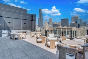 Una terrazza panoramica sul tetto con posti a sedere all'aperto e vista sullo skyline della città.