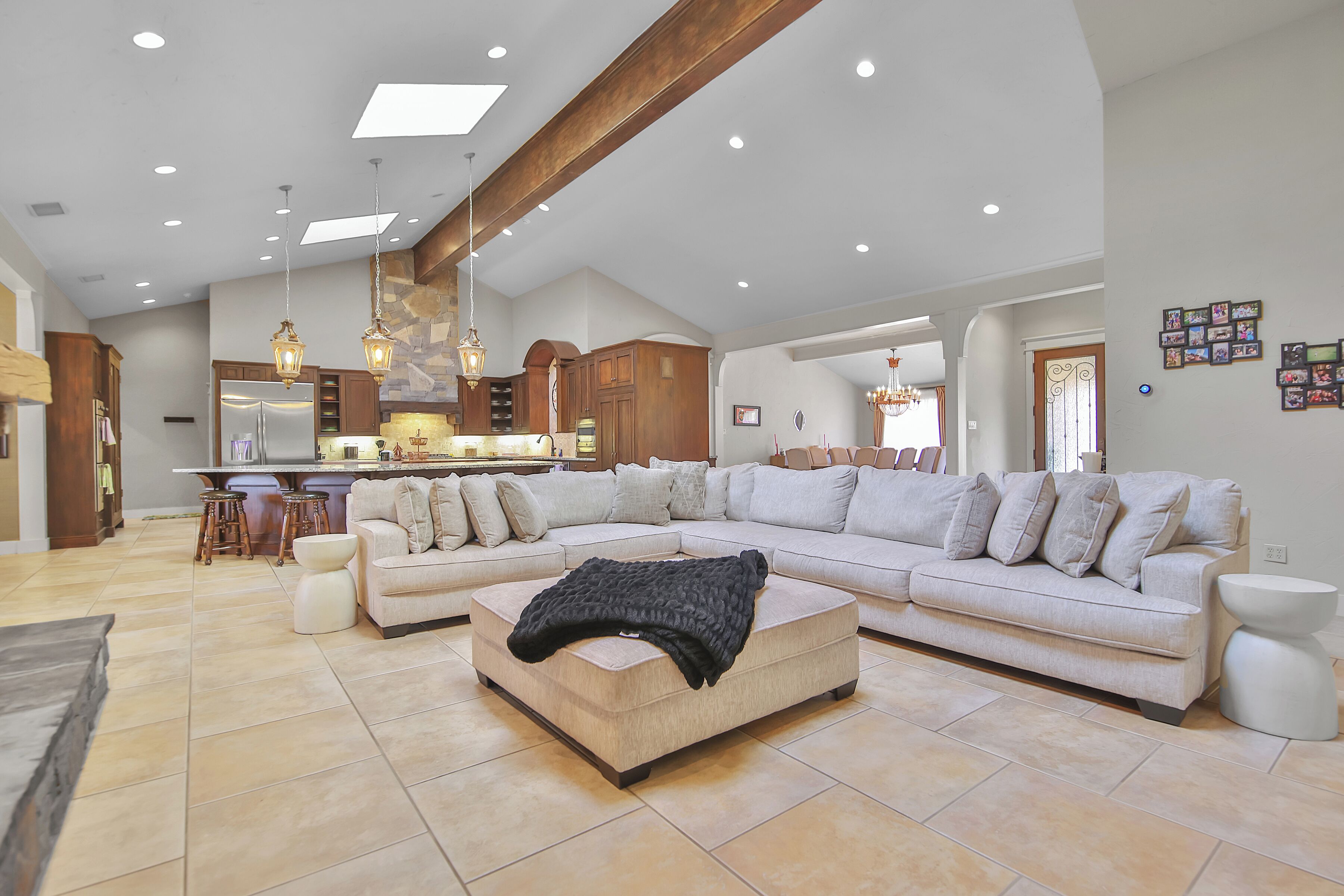 A spacious living area with a sectional sofa, a coffee table, and a kitchen in the background.