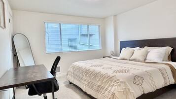 Un dormitorio con cama, escritorio y silla.