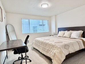 Une chambre à coucher avec un lit, un bureau et une chaise.