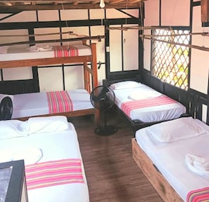 A room with bunk beds and a standing fan. - El Rincon de Juan (san onofre)