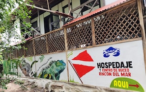 Una pared con un mural de un dinosaurio y texto que indica una ubicación.