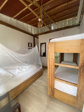 A room with a wooden bunk bed, a single bed with mosquito netting, and a ceiling fan. - El Rincon de Juan (san onofre)