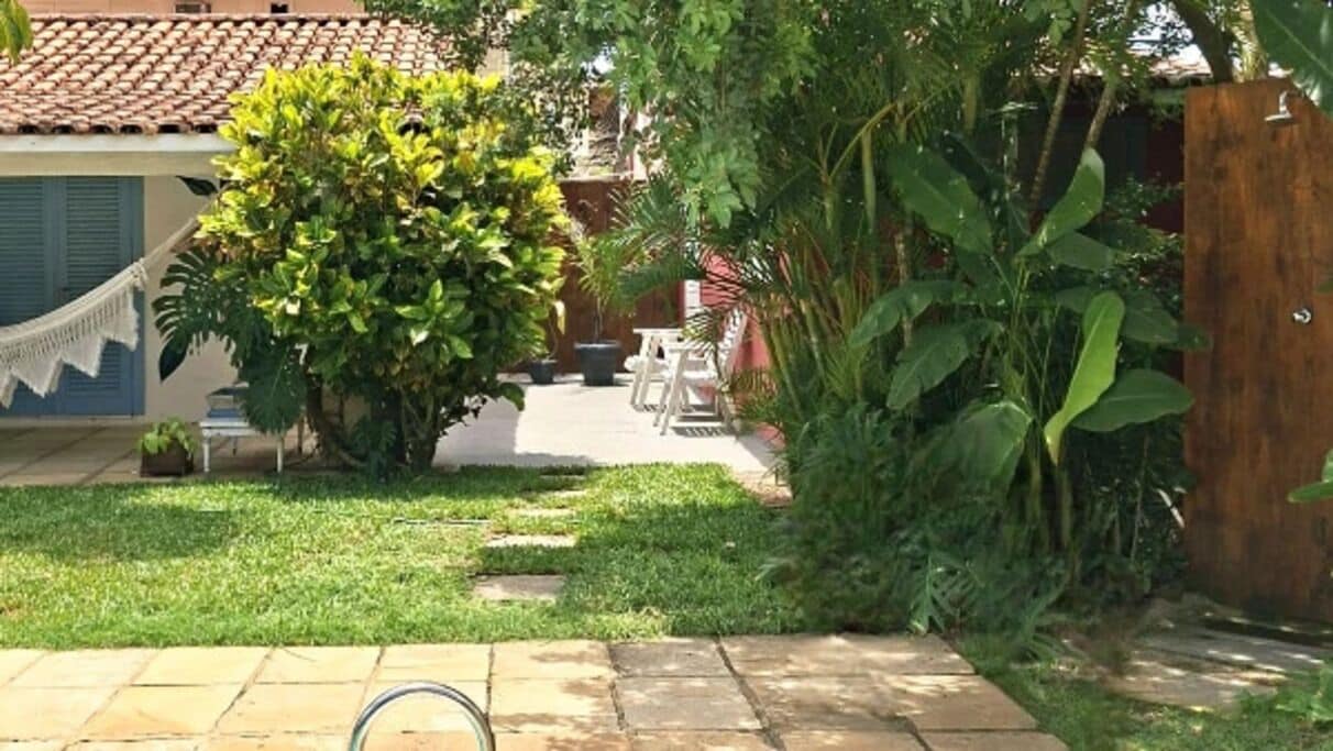 Un jardí amb cadira espanyola, zona de terrassa i tanca de fusta.
