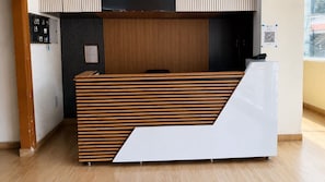 A reception desk with a slatted wooden design, a framed certificate on the wall, and a QR code on the right. - Deluxe IT Hub Khammam (Khammam)