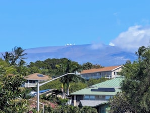 Ein Wohngebiet mit Häusern, einer Straßenlaterne und einem Berg im Hintergrund.