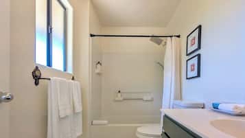 A bathroom with a shower, toilet, and sink.