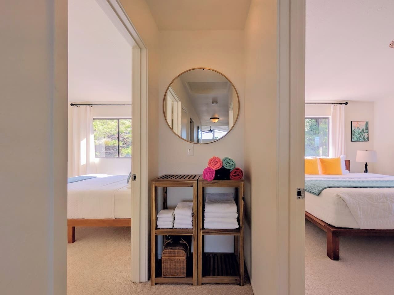 A bedroom with a bed, a bedside table, a lamp, and a mirror.