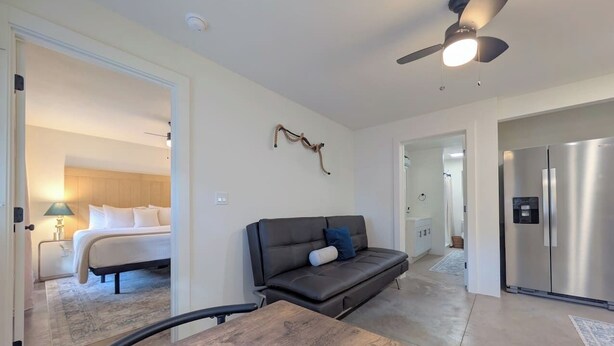 A modern interior with a sofa, a bed, a dining table, and a kitchen area. - Hale Maluhia, Newly renovated, 1BR, sleeps 3. (Waikoloa Village)