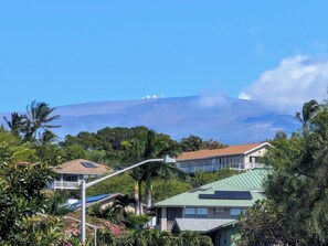 A residential area with houses, a street lamp, and a mountain in the background. - Hale Mauna, Waikoloa 1 House, 2 Units. (Waikoloa Village)