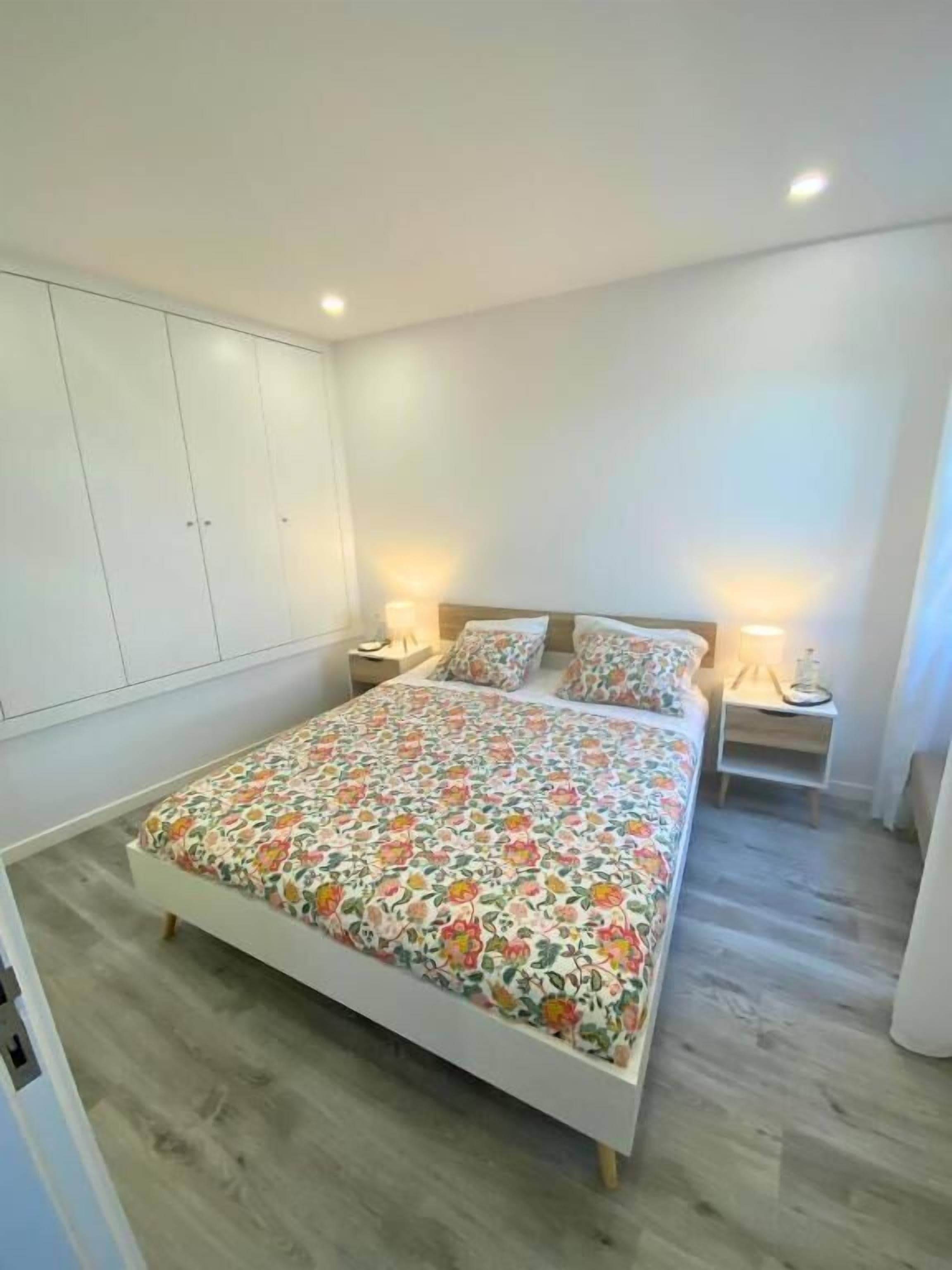 Ein Schlafzimmer mit einem Bett, Nachttischen und einem Kleiderschrank.