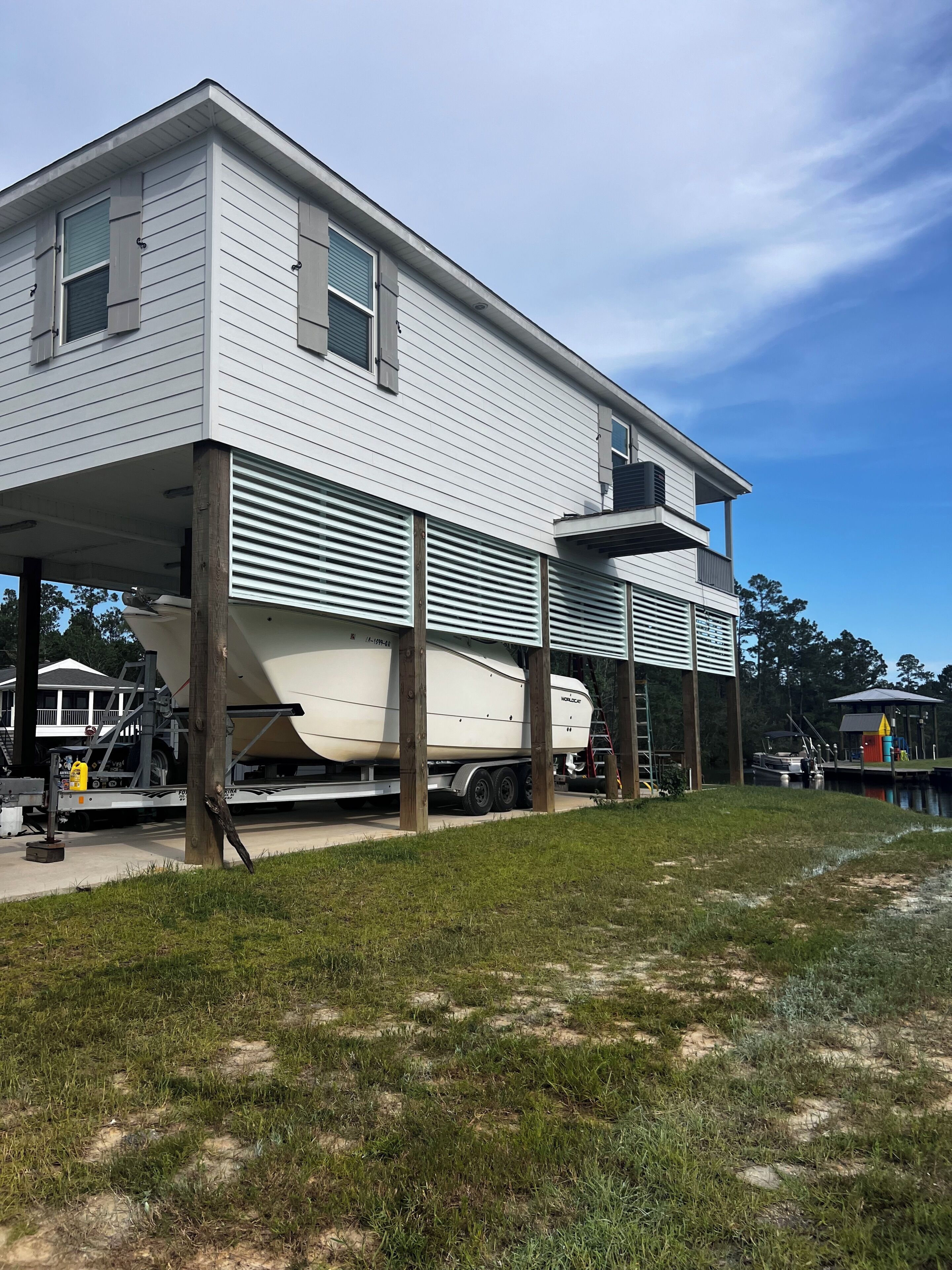 A two-story house with a covered outdoor area and a boat trailer.