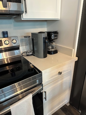 A kitchen with a stainless steel stove, a coffee maker, and a white countertop. - Spacious 3-bedroom house on the water in Bay St. Louis (Bay St. Louis)