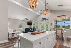 A spacious living area with a large island, ceiling fans, and a dining area with natural light. - Spacious 3-bedroom house on the water in Bay St. Louis (Bay St. Louis)