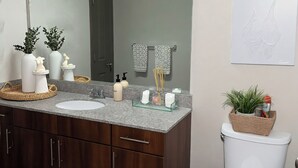 Ein modernes Badezimmer mit Waschtisch, Spüle, Spiegel und Toilette.