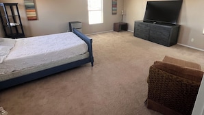 A bedroom with a bed, a TV, a dresser, and a window. - Goodyear 2 Story (Goodyear)