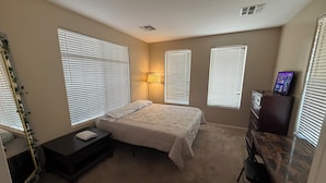 A bedroom with a bed, bedside table, dresser, and a desk with a chair. - Goodyear 2 Story (Goodyear)