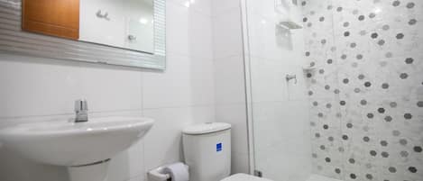 A bathroom with a sink, toilet, and shower.