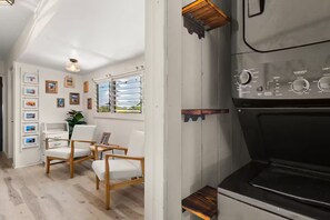Eine Küche mit eingebautem Backofen, einer fest installierten Bedienkonsole und einem Fenster mit Jalousien.