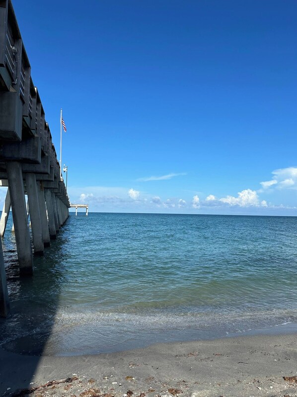A pier extending into calm waters with a clear sky.